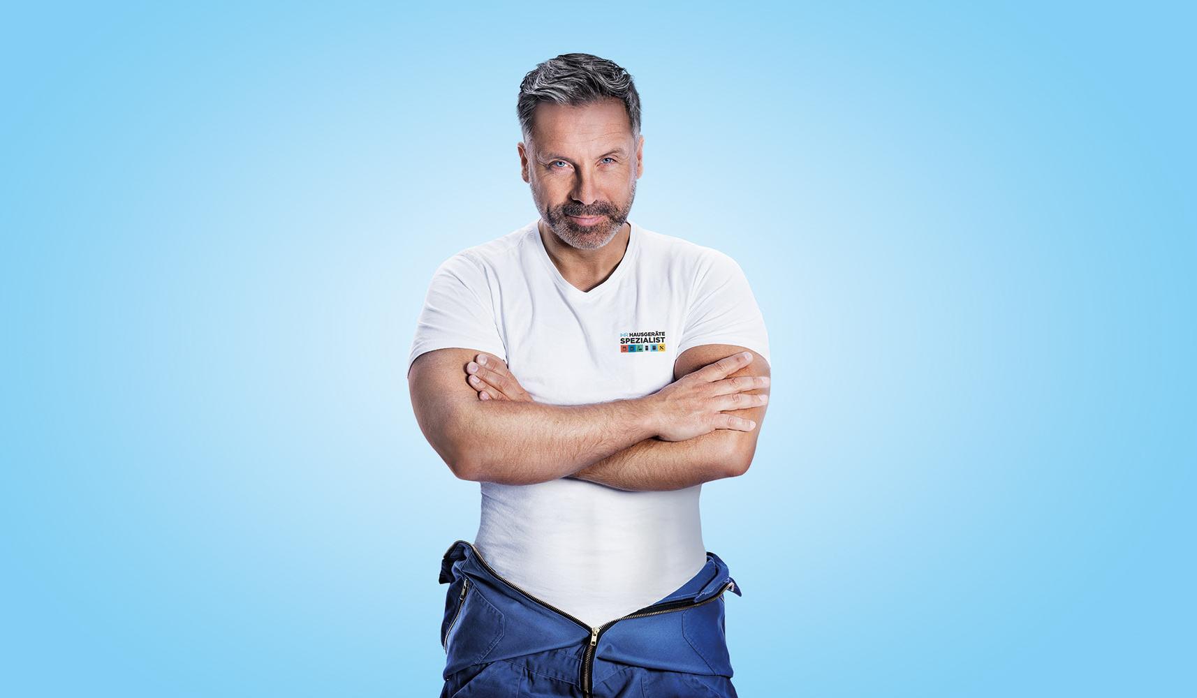 Service-Techniker im Blaumann mit verschränkten Armen